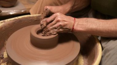 Çömlekçi bir adamın çömlekçinin kilden bir çanak çömlek yapmasını yakından çek.