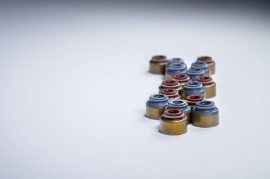 Gri bir arka planda emme ve egzoz vanaları için yeni yağ kapakları seti.