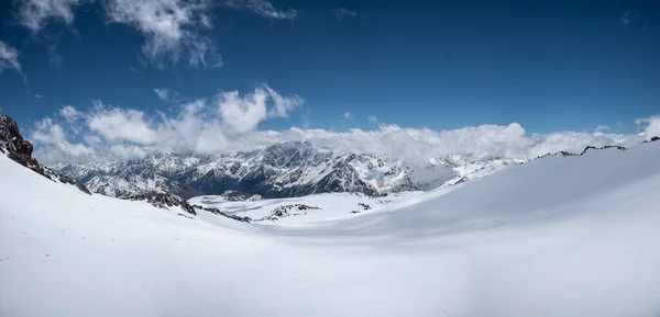 Alpine panorama van de grote Kaukasische bergkam bedekt met sneeuw op een zonnige dag met variabele bewolking. Ideale pistes voor ski 's en freeride ski en snowboarden — Stockfoto