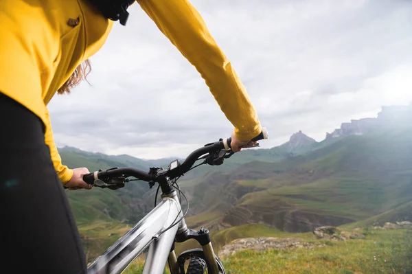 在史诗般的岩石和山脉的背景下骑山地自行车的女骑手的特写镜头。山地自行车。骑自行车者 — 图库照片
