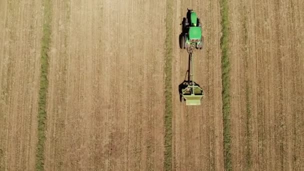 Vista aérea de um trator com um cortador de relva corta a grama em um campo vazio. Preparação e manutenção de campo durante todo o ano — Vídeo de Stock