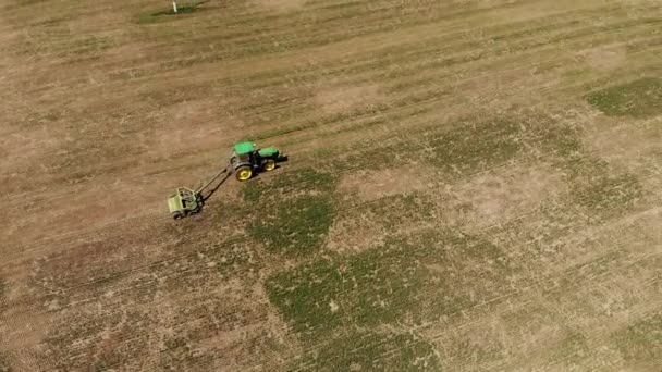 Vista aérea de um trator com um cortador de relva corta a grama em um campo vazio. Preparação e manutenção de campo durante todo o ano — Vídeo de Stock