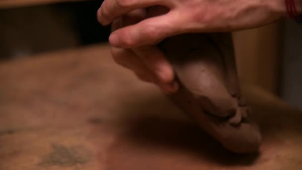 Close-up van een man pottenbakker kneden klei verslaat het voor installatie op een pottenbakkerswiel — Stockvideo