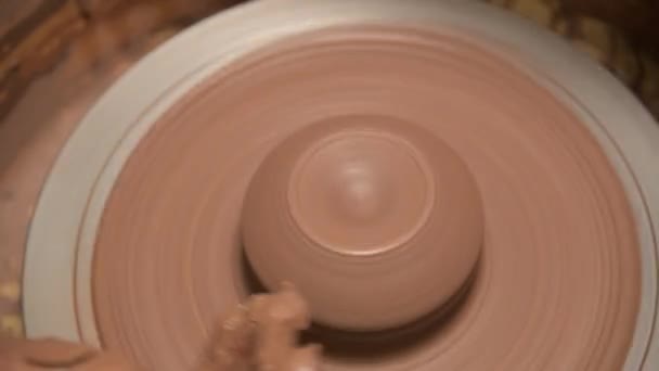 Close-up of a man potter making a clay bowl on a potters wheel from clay — Stock Video