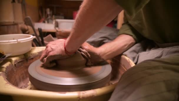 Close-up of a man potter making a clay bowl on a potters wheel from clay — Stock Video