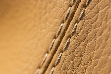 Bej rengi, eski deri kaplama kaplama, dikişli makro. Tekstil otomatik arkaplan