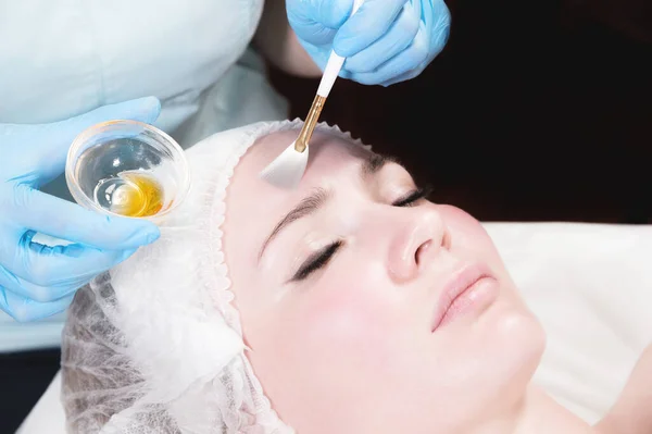 美容院的美容师在顾客脸上戴上防护面具。面部皮肤护理和美容治疗 — 图库照片