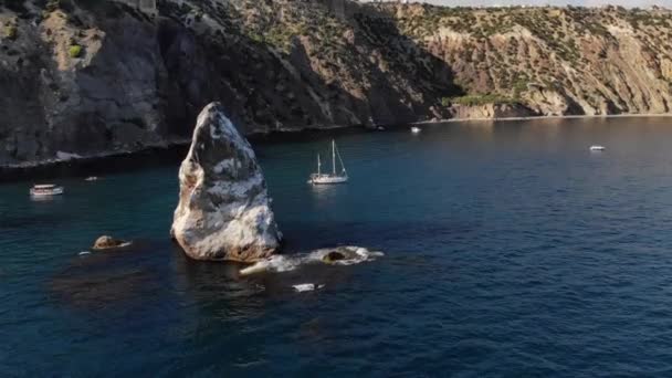 Aerial view of the rocky coast of the bay with detached rocks and boats with tourists swimming around them. Turquoise ocean water in the coastal strip — Stock Video