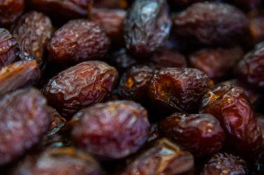 Seçilen kurutulmuş tarihlerin yüzey dokusu. Doğuya özgü tatlılar. Kurutulmuş kurutulmuş meyvelerin yakın plan çekimi..