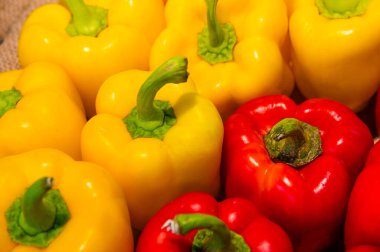 Marketteki tezgahta kırmızı ve sarı dolmalık biberlerin yakın çekimi. Vejetaryen geçmişi. Zengin renk.