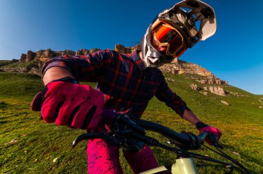 Spor haberleri. Bir bisikletçi tarlada tek başına durur. Yokuş aşağı bisiklet süren biri.