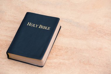 Top View of Holy Bible on Sandstone clipart