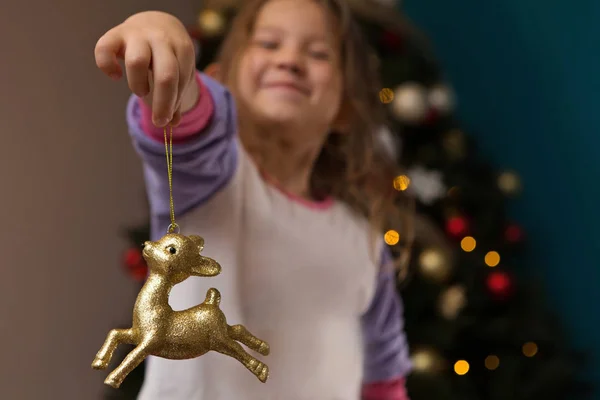 Happy Young Girl Smiling Holding Gold Reindeer Ornament — Stock Photo, Image