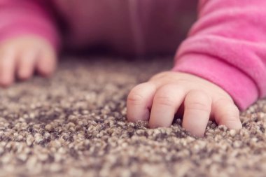 Tatlı küçük bebek kız el alarak ilk tarama adımları halı üzerinde