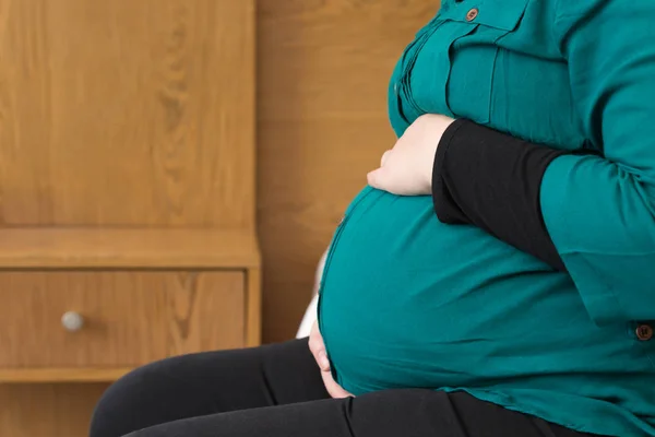 Werdende Mutter hält wachsenden Babybauch in der Hand — Stockfoto