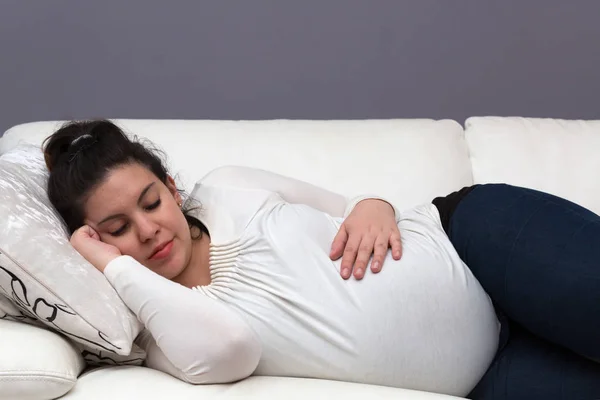 ソファで眠る疲れた妊婦のお母さん — ストック写真