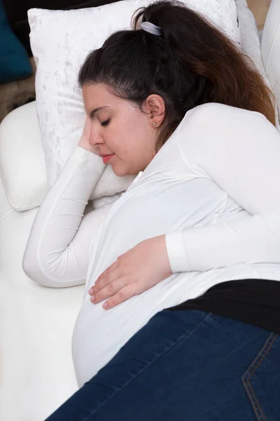 Fáradt várandós anya alszik a kanapén — Stock Fotó