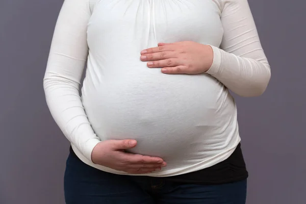 Werdende Mutter hält wachsenden Babybauch in der Hand — Stockfoto