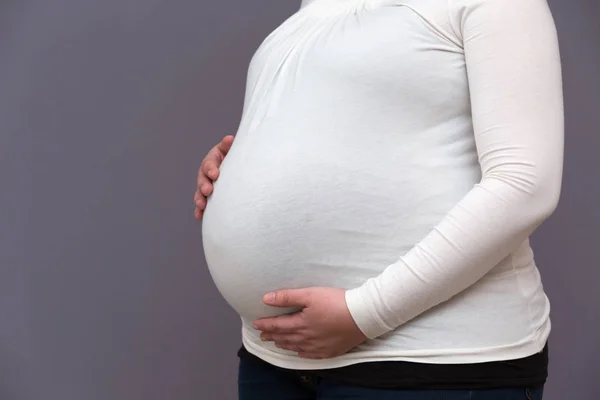 Blivande mamma håller växande baby bump — Stockfoto