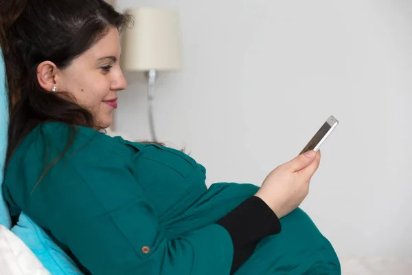 Boldog várandós fiatal anyu keresés rajta smartphone — Stock Fotó