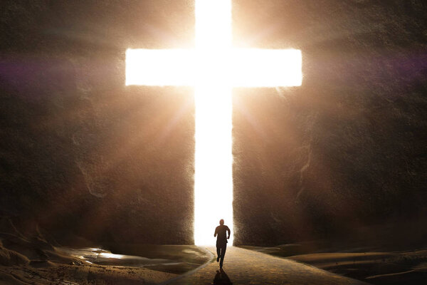 Человек, бегущий к гигантскому яркому кресту с сияющими лучами
