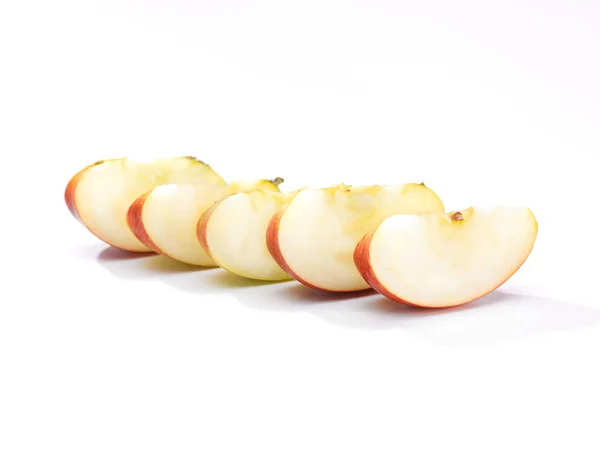 five pieces of sliced apple on a white background