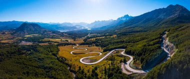 Aerial panorama of the curved asphalt road trough mountains. Carretera Austral road near the Cerro Castillo National Park. Chile clipart