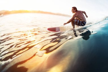 Sörfçü güneş doğarken tropik yerlerde camsı dalgalarda sörf yapar. Kosta Rika