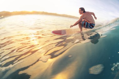 Sörfçü güneş doğarken tropik bölgelerde sörf yapar. Kosta Rika