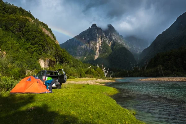 Tält Som Ligger Grön Äng Flodkust Med Berg Och Regnbåge — Stockfoto