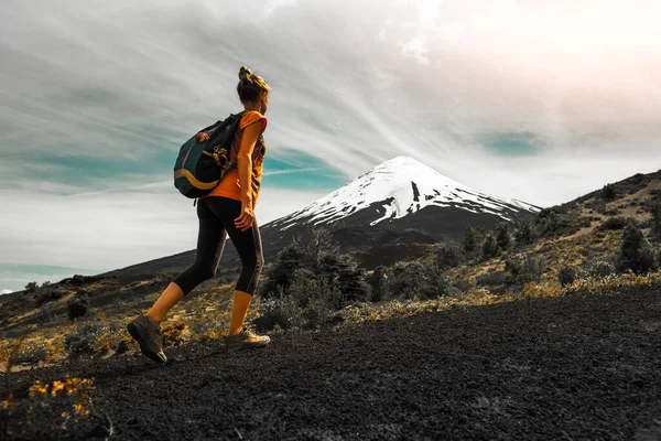 ハイカーは火山の斜面を歩きます チリのオソルノ火山の景色を眺めながらトレイルを楽しむ女性 — ストック写真