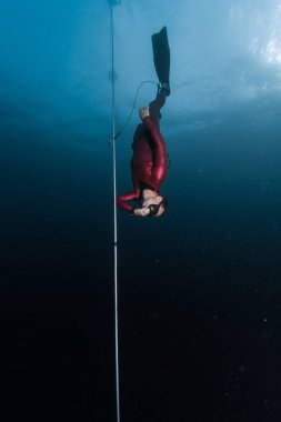 Freediver serbest düşüş aşamasında ip boyunca süzülür. Ele avuca sığmıyor ve bacağında emniyet tasması var.