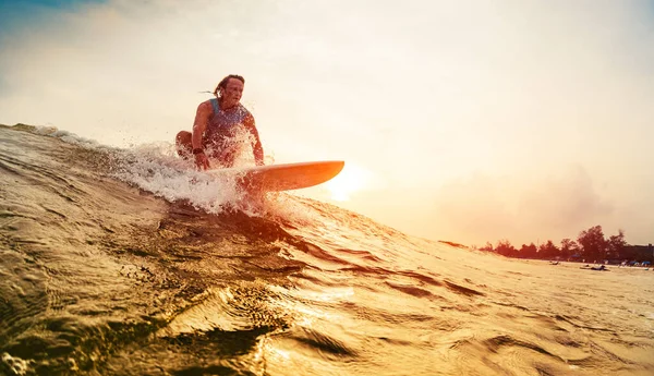 若いサーファーは日没時に波に乗る — ストック写真