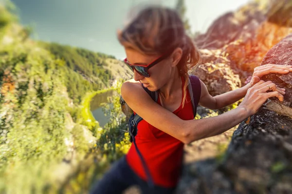 女性ハイカーは岩の崖を登ります ティルトシフト効果を適用 — ストック写真