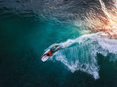 Bodyboard sörfçüsü Oahu 'da günbatımında tropik dalgalara biner. Hawaii