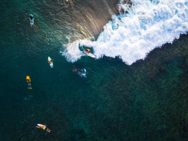 Küçük dalgalarla eğlenen sörfçülerin hava görüntüsü. Oahu, Hawaii