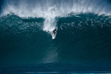 OAHU / USA - 05 Aralık 2018: Sörfçü, Oahu 'nun kuzey kıyısındaki sörf fırsatlarıyla ünlü Banzai Boru Hattı' nın dev dalgasına bindi.