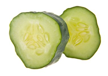 Dilimlenmiş yeşil salatalıklar beyaz arka planda izole edilmiş.