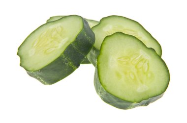 Dilimlenmiş yeşil salatalıklar beyaz arka planda izole edilmiş.