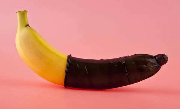 Banane Jaune Avec Préservatif Noir Sur Fond Rose — Photo