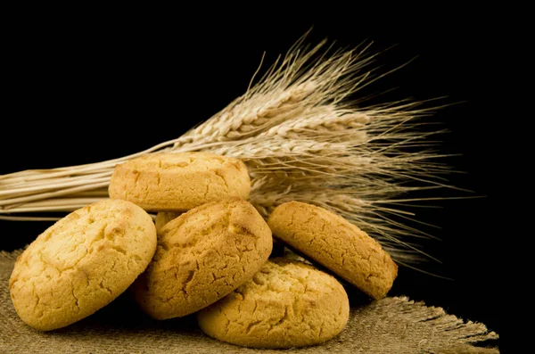 自制的饼干和小穗的小麦隔离在黑色背景特写镜头 — 图库照片