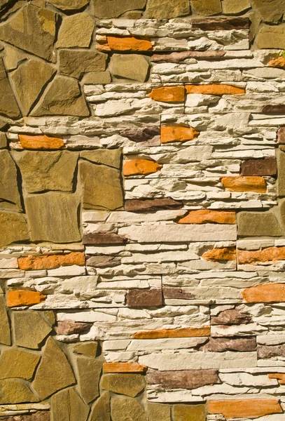 壁を背景として様々 な石で覆われています — ストック写真