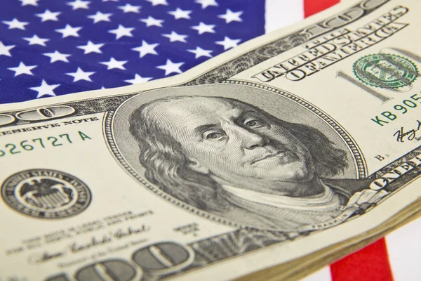 Доллары на флаге США в качестве фона — стоковое фото