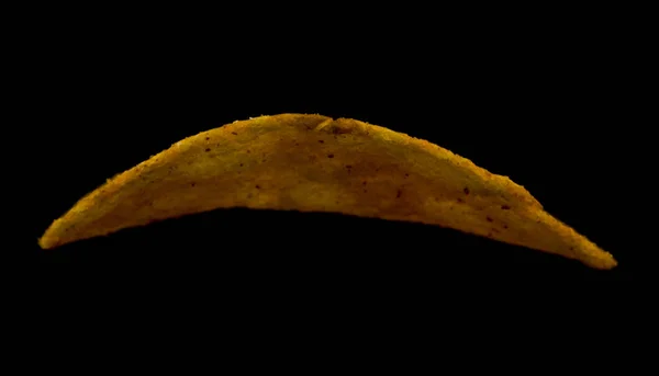 Chipsy ziemniaczane izolowane na czarnym tle zbliżenie — Zdjęcie stockowe