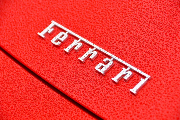 Ferrari skylt på vått rött karosseri — Stockfoto