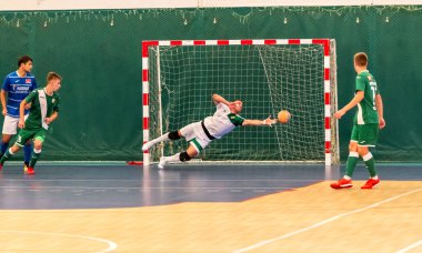 Odessa, Ukraine - July 28 2018: Unidentified players of local team playing in mini-football tournament in futsal on parquet floor. Moment of sport game in football in closed hall, mini football clipart