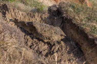 Sesmically tehlikeli bölgede dağ heyelan felaketi. Toprak, toprak engelleme yolun büyük katmanları kökenli büyük çatlaklar. İnsanlara heyelan pistlerinin dağın damming, ölümcül bir tehlike