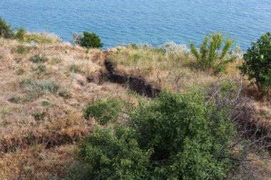 Sesmically tehlikeli bölgede dağ heyelan felaketi. Toprak, toprak engelleme yolun büyük katmanları kökenli büyük çatlaklar. İnsanlara heyelan pistlerinin dağın damming, ölümcül bir tehlike
