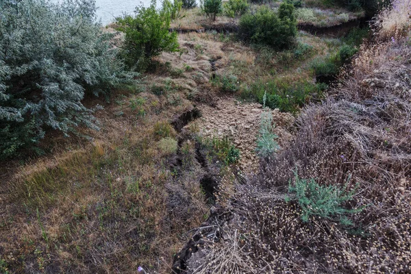 Sesmically tehlikeli bölgede dağ heyelan felaketi. Toprak, toprak engelleme yolun büyük katmanları kökenli büyük çatlaklar. İnsanlara heyelan pistlerinin dağın damming, ölümcül bir tehlike