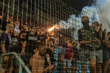 Odessa, Ukrayna-July2, 2018: fanatik hayranları standları ebedi rakip oyun sırasında. Raflar taraftarlara mutlu, yangın ve dalgalanan bayrak ile kızdırma. Ateşli gösteri Stadyumu'nda. Holigan hafif ateşli flashe hayranları